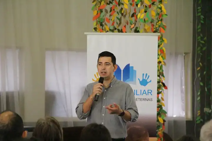 Un facilitador de Misión Auxiliar enseñando frente a un grupo durante una actividad de formación.